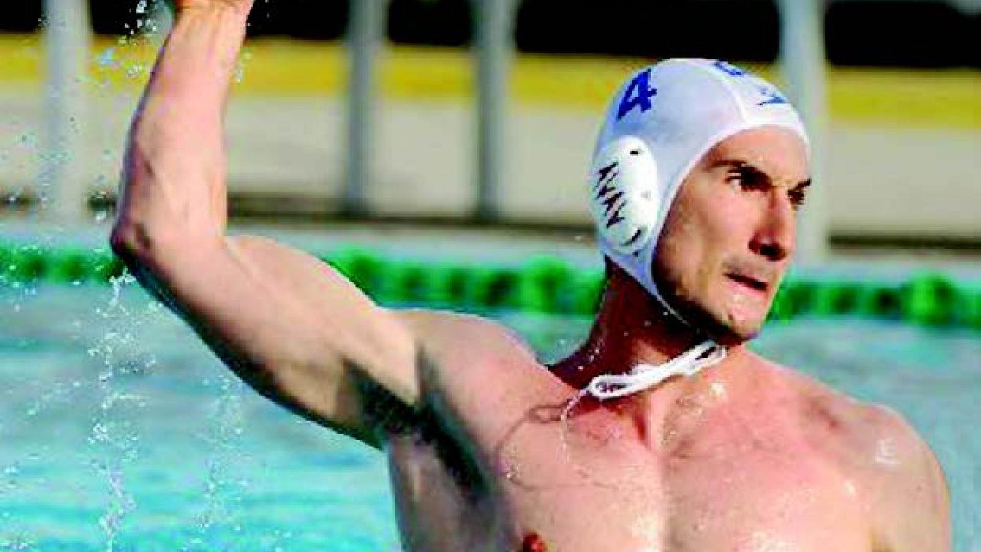 Kevin Mitchel winds up to throw a watersport ball in the middle of a pool.